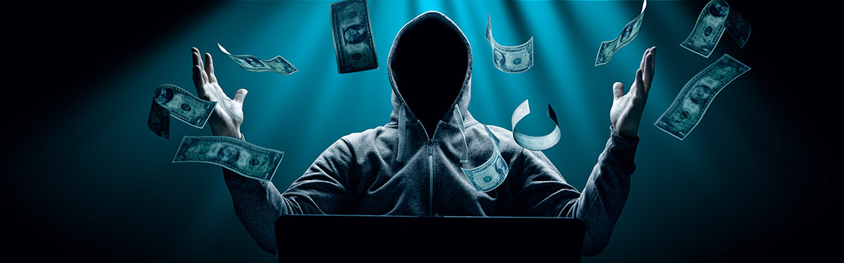 Hacker in front of computer surrounded by falling dollar bills